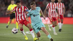 Pemain Barcelona, Fermin Lopez, berusaha melewati pemain Almeria, Lucas Robertone, dalam laga jornada 36 La Liga di Power Horse Stadium, Jumat (17/5/2024). Dua gol kemenangan Barcelona di markas Almeria diborong oleh gelandang Fermin Lopez, masing-masing dicetak di babak pertama dan kedua. (AFP/Jorge Guerrero)