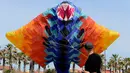 Seorang peserta berusaha menerbangkan layang-layang saat mengikuti Festival Internacional del Viento (Festival Angin Internasional) di pantai Malvarrosa, di Valencia, Spanyol (23/4). (AFP/Jose Jordan)