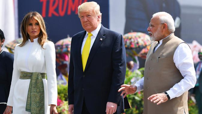 PM India, Narendra Modi berbincang dengan Presiden AS Donald Trump dan Melania Trump saat menyambut kedatangan mereka di Bandara Internasional Sardar Vallabhbhai Patel di Ahmedabad, Senin (24/2/2020). Ini merupakan kunjungan balasan Trump setelah Modi berkunjung ke AS pada 2019. (MANDEL NGAN/AFP)
