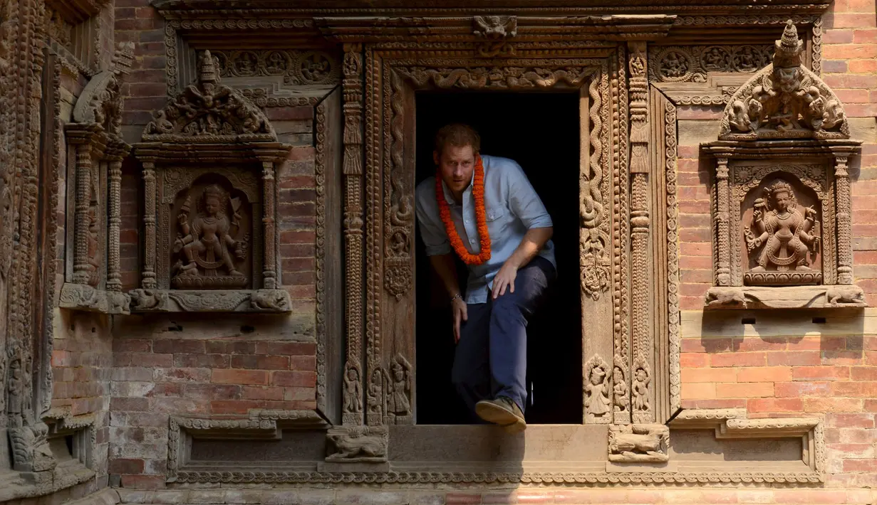 Putra Mahkota Kerajaan Inggris, Pangeran Harry, ketika mengunjungi salah satu situs warisan dunia, Patan Durbar Square di Kathmandu, Nepal, Minggu (20/3). (REUTERS/Prakash Mathema/Pool)