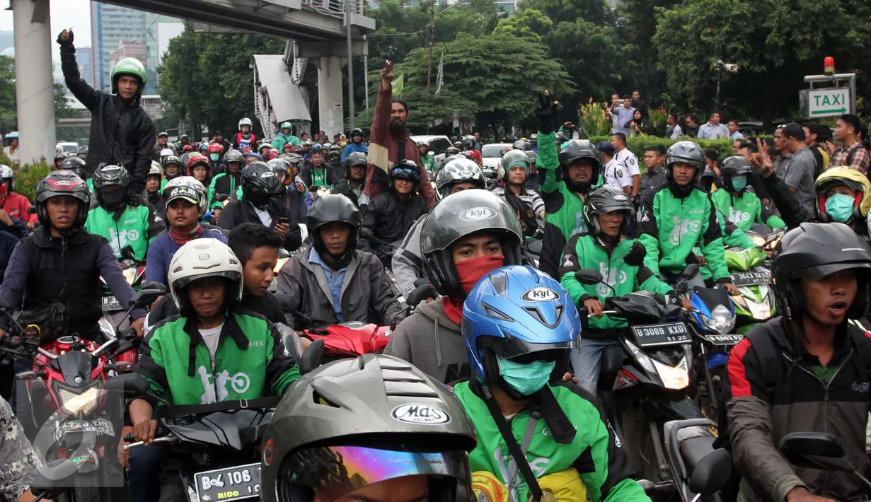 Pengemudi Ojek Online melakukan aksi sweeping terhadap taksi di kawasan Kuningan, Jakarta, Selasa (22/3). Sebuah taksi mengalami kerusakan akibat aksi anarkis dari sejumlah orang. (Liputan6.com/Helmi Afandi)