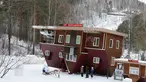 Seorang pekerja berpakaian seperti Ded Moroz atau Santa Claus dari Rusia bersama cucunya Snegurochka duduk di kereta Rusa menyambut pengunjung rumah terbalik Royev Ruchey Park, Krasnoyarsk, Rusia (7/12). (Reuters/Ilya Naymushin)