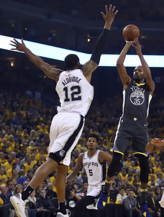 Kevin Durant melepaskan tembakan melewati adangan pemain San Antonio Spurs, LaMarcus Aldridge pada playoffs NBA Basketball di Oracle Arena, Oakland, California, (16/4/2018). Warriors menang 116-101. (AP/Ben Margot)