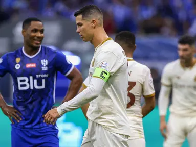 Pemain Al-Nassr, Cristiano Ronaldo, tertunduk lesu setelah ditaklukkan Al-Hilal pada laga Liga Arab Saudi 2022/202 di Stadion King Fahd, Rabu (19/4/2023). Mantan striker Manchester United (MU) Odion Ighalo menjadi bintang kemenangan Al Hilal. (AFP/Fayez Nureldine)