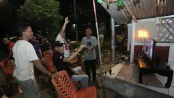 Sejumlah warga meluapkan kebahagiaan setelah Timnas Indonsia mengalahkan Bahrain dalam pertandingan Grup C putaran ketiga Kualifikasi Piala Dunia 2026 zona Asia di kawasan Menteng Jaya, Jakarta, Selasa (25/5/2025). (Bola.com/M Iqbal Ichsan)