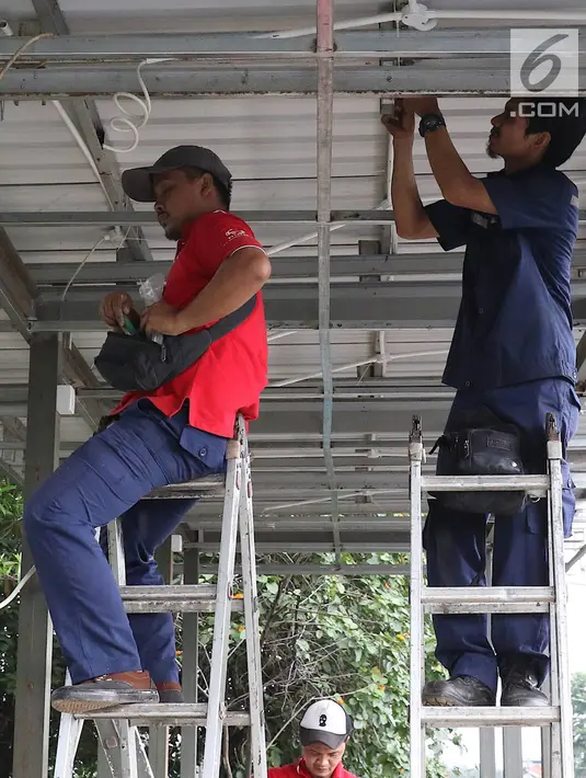 Pekerja menyelesaikan pembuatan halte Transjakarta di kawasan Kampung Rambutan, Jakarta, Jumat (1/3). Pembuatan halte tersebut bertujuan mempermudah warga untuk mengakses bus Transjakarta. (Liputan6.com/Immanuel Antonius)