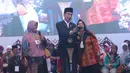 Presiden Jokowi berselfie dengan warga di Pondok Pesantren Miftahul Huda, Tasikmalaya, Jawa Barat, Rabu (27/2). Kedatangan Jokowi merupakan bagian dari rangkaian Penyaluran KUR Ketahanan pangan dan aksi ekonomi untuk rakyat. (Liputan6.com/Angga Yuniar)
