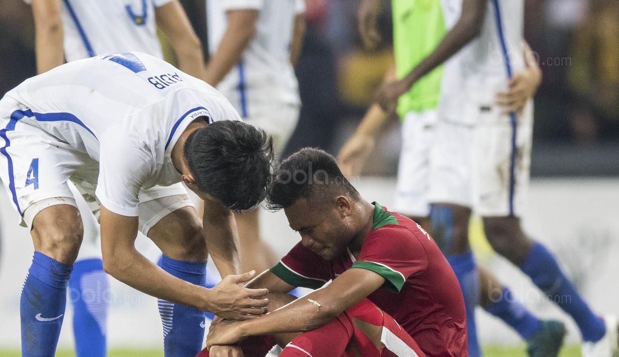 Pemain Malaysia menghibur gelandang Timnas Indonesia, Saddil Ramdani, yang menangis karena kalah pada laga semifinal SEA Games di Stadion Shah Alam, Selangor, Sabtu (26/8/2017). Indonesia kalah 0-1 dari Malaysia. (Bola.com/Vitalis Yogi Trisna)