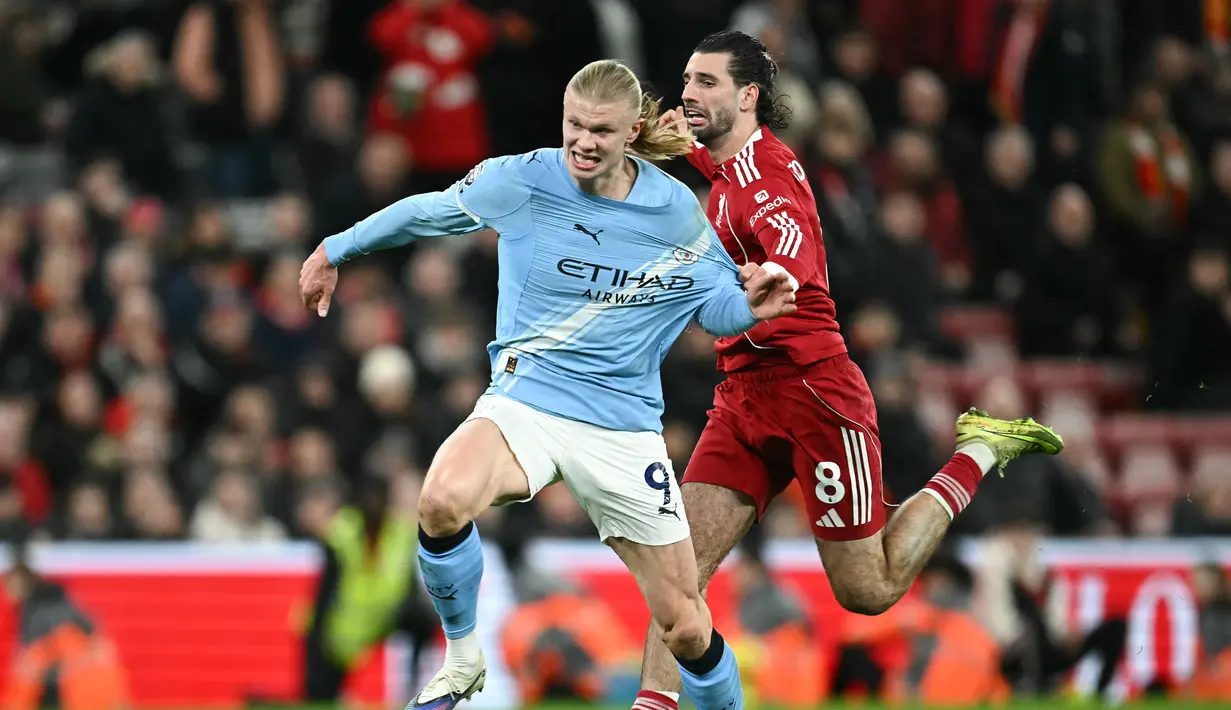 Pemain Liverpool, Dominik Szoboszlai, menarik baju pemain Manchester City, Erling Haaland, pada laga Liga Inggris di Stadion Anfield, Senin (9/2/2026) dini hari WIB. (AFP/Paul Ellis)