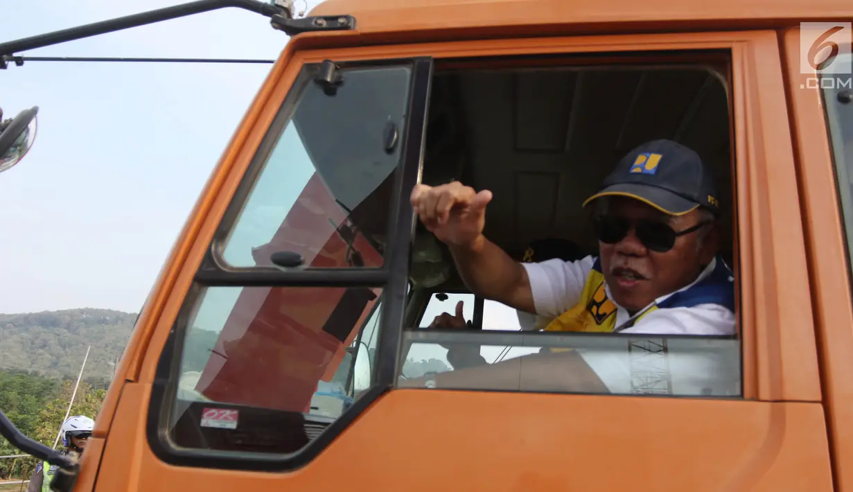Menteri PUPR Basuki Hadimuljono mengacungkan jempol kepada wartawan saat menaiki truk untuk melintasi Jembatan Kali Kuto di Batang, Jateng, Rabu (13/6). Jembatan Kali Kuto mampu menahan beban hingga 16 ton. (Liputan6.com/Arya Manggala)