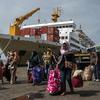 Penumpang tiba di pelabuhan di Surabaya, Jawa Timur, Kamis (28/4/2022). Orang-orang melakukan perjalanan ke kota asalnya menjelang Idul Fitri yang menandai berakhirnya bulan suci Ramadhan. (Juni Kriswanto/AFP)