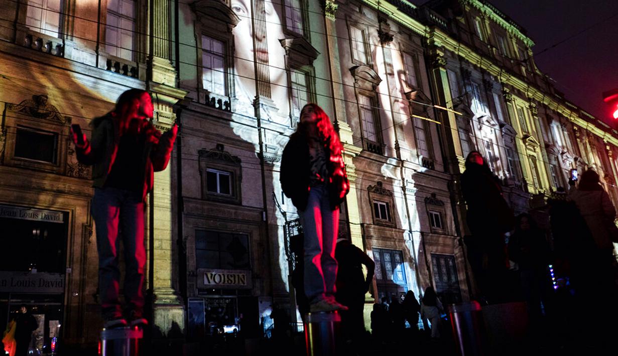 Orang-orang menghadiri pertunjukan cahaya malam di Lyon, Prancis, 8 Desember 2022. Jutaan orang diperkirakan akan menyaksikan acara Festival Cahaya selama empat hari di kota tersebut. (AP Photo/Laurent Cipriani)