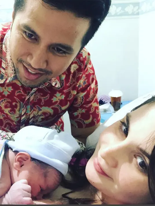 Pesinetron cantik itu tampak tersenyum manis mengabadikan momen bersama putranya. Di sampingnya sang suami ikut menemani proses persalinannya. (Via Instagram/@Arumi_arumi_94)