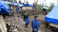 Sejumlah perempuan Suku Baduy Luar berjalan di lokasi bekas kebakaran Kampung Cisaban II, Desa Kanekes, Banten, Kamis (01/6). Warga Baduy Luar mulai membangun kembali rumah mereka yang terbakar beberapa waktu lalu. (Liputan6.com/Fery Pradolo)