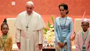Paus Fransiskus berpose bersama pemimpin de facto Myanmar, Aung San Suu Kyi dalam pertemuan mereka di Naypyitaw, Selasa (28/11). Paus Fransiskus bertemu dengan Suu Kyi untuk membahas mengenai krisis kemanusiaan di Rakhine. (AP Photo/Andrew Medichini)