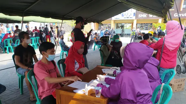 Nampak para petugas tenaga kesehatan (Nakes) tengah sibuk melakukan vaksinasi Covid-19 yang diselenggarakan Hiswana Migas Garut, bagi peserta yang berasal dari mitra Pertamina serta masyarakat sekitar.