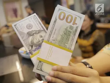 Teller menghitung mata uang dolar di penukaran uang di Jakarta, Jumat (20/4). Nilai tukar rupiah terhadap dolar Amerika Serikat (AS) mengalami pelemahan. (Liputan6.com/Angga Yuniar)