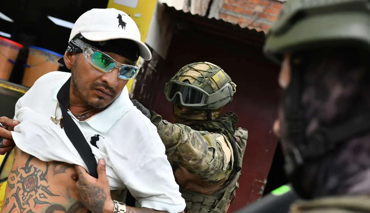 Tentara memeriksa punggung seorang pria untuk memeriksa tato geng selama operasi penghentian dan penggeledahan di Portoviejo, Ekuador, Kamis (11/1/2024). Presiden Ekuador Daniel Noboa pada Senin menetapkan keadaan darurat nasional karena gelombang kejahatan, sebuah tindakan yang memungkinkan pihak berwenang menangguhkan hak-hak masyarakat dan memobilisasi militer. (AP Photo/Ariel Ochoa)
