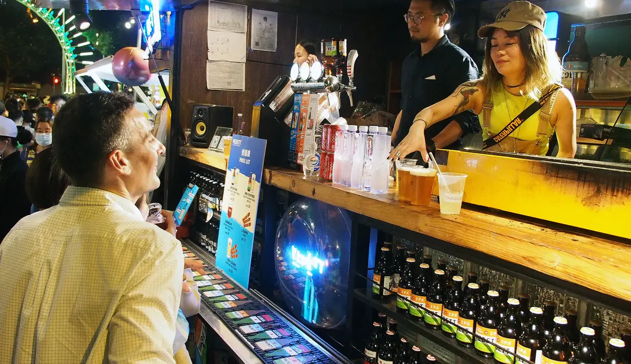 Orang-orang membeli minuman di sebuah jalan di Shanghai, China timur, pada 7 Juni 2020. Berbagai bar, museum, toko buku, pusat perbelanjaan, serta kompleks komersial penting bergabung ke dalam festival yang digelar untuk mendorong aktivitas perekonomian malam hari di kota tersebut. (Xinhua/Chen Fei)