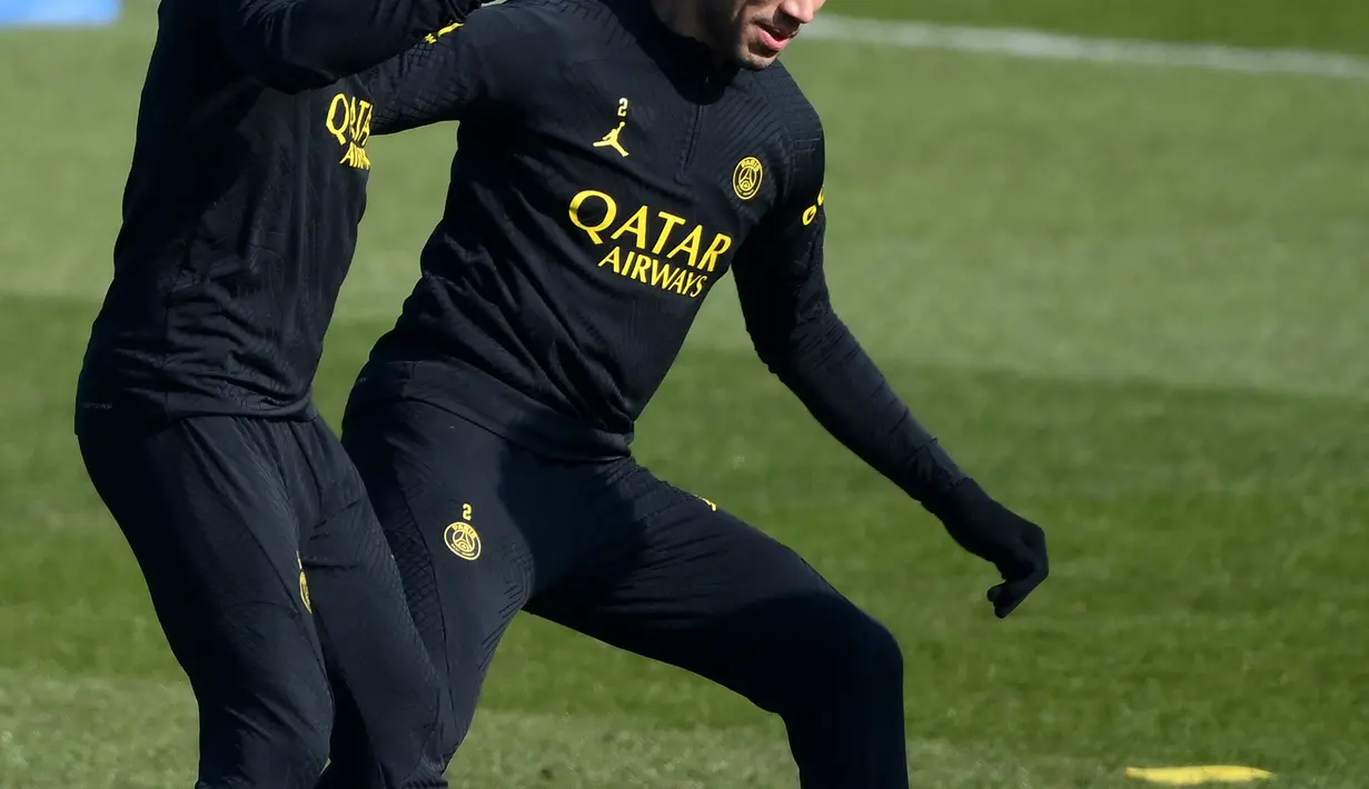 <p>Bek PSG Achraf Hakimi (kanan) bermain bola dengan Marco Verratti saat sesi latihan jelang menjamu Nantes pada Liga Prancis, di tempat latihan klub di Saint-Germain-en-Laye, sebelah barat Paris, Jumat (3/3/2023). Hingga kini, PSG sudah mengumpulkan 60 poin dari 25 laga, unggul 8 angka dari pesaing terdekat mereka, Marseille. (Photo by FRANCK FIFE / AFP)</p>