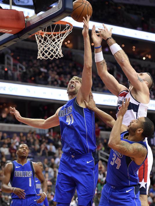 Pebasket Dallas Mavericks, Dirk Nowitzki, berusaha menghalau pebasket Washington Wizards, Marcin Gortat, pada laga NBA di Capital One Arena, Selasa (7/11/2017). Mavericks menang 113-99 atas Wizards. (AP/Nick Wass)