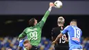 Kiper AC Milan, Gianluigi Donnarumma, menghalau bola saat melawan Napoli pada laga Serie A di Stadion San Paolo, Minggu, (12/7/2020). Kedua tim bermain imbang 2-2. (Cafaro/LaPresse via AP)