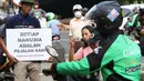 Aktivis Koalisi Pejalan Kaki (KPK) membawa poster himbauan saat menghadang pengendara sepeda motor yang menerobos trotoar di depan Tempat Pemakaman Umum (TPU) Menteng Pulo, Jalan Casablanca, Jakarta Selatan, Jumat (21/7). (Liputan6.com/ Immanuel Antonius)