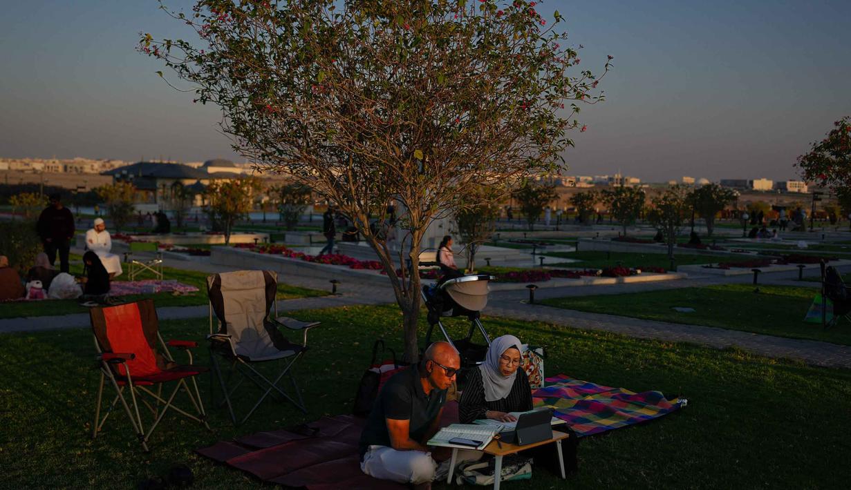 Masjid Agung Sharjah resmi dibuka untuk umum pada tahun 2019. Tampak dalam foto, sepasang suami istri Muslim membaca Al-Quran di kompleks Masjid Agung Sharjah, dekat Dubai, Uni Emirat Arab, Jumat 27 Februari 2026. (AP Photo/Altaf Qadri)