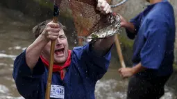 Seorang Nelayan bergembira usai mendapatkan ikan saat hari nelayan di Memmingen, Jerman, Sabtu (25/7/2015). Peserta yang menangkap ikan terbesar akan diberi nama "Raja Nelayan" selama satu tahun. (REUTERS/Michaela Rehle)