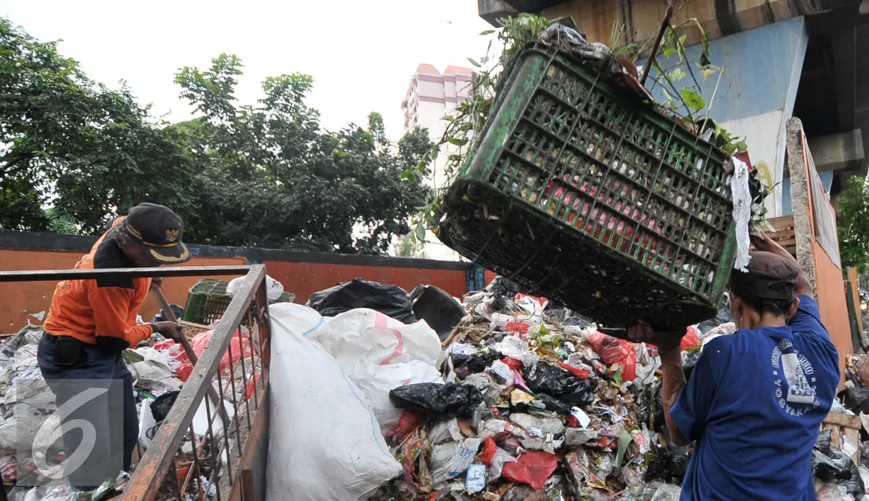 Petugas kebersihan memindahkan sampah yang telah diangkut dari rumah warga ke tempat pembuangan sampah sementara (TPSS), Pasar Baru, Jakarta, Jumat (25/11). Dalam sehari, Kelurahan Pasar Baru menghasilkan sampah mencapai 3 ton. (Liputan6.com/Yoppy Renato)