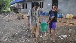 Dua orang warga mengangut air di Kawasan Manggarai, Jakarta, Selasa, (10/11). Hampir dua bulan warga RW 10 Manggarai Selatan harus antre untuk mendapat air bersih.(Liputan6.com/Gempur M Surya)
