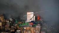 Pemadam kebakaran berusaha memadamkan api di sebuah gudang di Kharkiv, Ukraina, yang hancur dalam serangan rudal Rusia. (dok. SERGEY BOBOK / AFP)