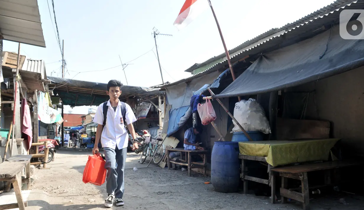 Anak sekolah melintas di permukiman Kampung Baru, Cilincing, Jakarta, Selasa (22/10/2019). Kondisi permukiman di kawasan ini hampir seluruhnya terbuat dari bangunan semipermanen, bahkan ada yang terlihat mirip gubuk dengan fasilitas MCK memprihatinkan. (merdeka.com/Iqbal Nugroho)