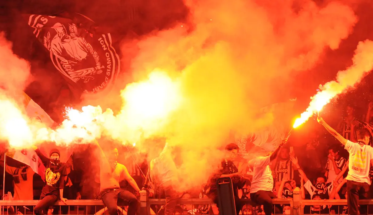 Suporter I Bianconeri menyalakan kembang api usai menyaksikan laga persahabatan ISL All Stars kontra Juventus di Stadion GBK, Jakarta, (6/8/2014). (Liputan6.com/Helmi Fithriansyah)
