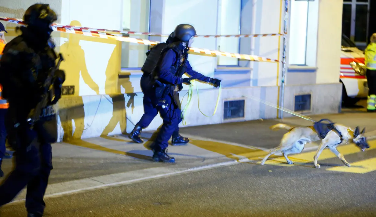Petugas polisi mengerahkan anjing pelacak di lokasi penembakan di sebuah masjid kota Zurich, Swiss, Senin (19/12). Sedikitnya tiga orang luka-luka saat seorang pria menyerbu masuk dan menembak jamaah yang tengah menunaikan salat. (REUTERS/Arnd Wiegmann)