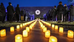 Sejumlah orang ambil bagian dalam acara penyalaan lilin untuk mengenang para korban Pembantaian Nanjing di hari peringatan nasional ketujuh di Balai Peringatan Korban Pembantaian Nanjing oleh Tentara Jepang di Nanjing, ibu kota Provinsi Jiangsu, China timur, pada 13 Desember 2020. (Xinhua/Li Bo)