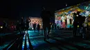 Sepasang kekasih berpelukan di depan Berlin State Opera (Staatsoper) yang diterangi cahaya dalam Festival of Lights di Berlin pada 14 September 2020. Kreasi cahaya lebih dari 90 karya seni tersebut ditampilkan di 86 lokasi yang berlangsung hingga 20 September mendatang. (John MACDOUGALL/AFP)