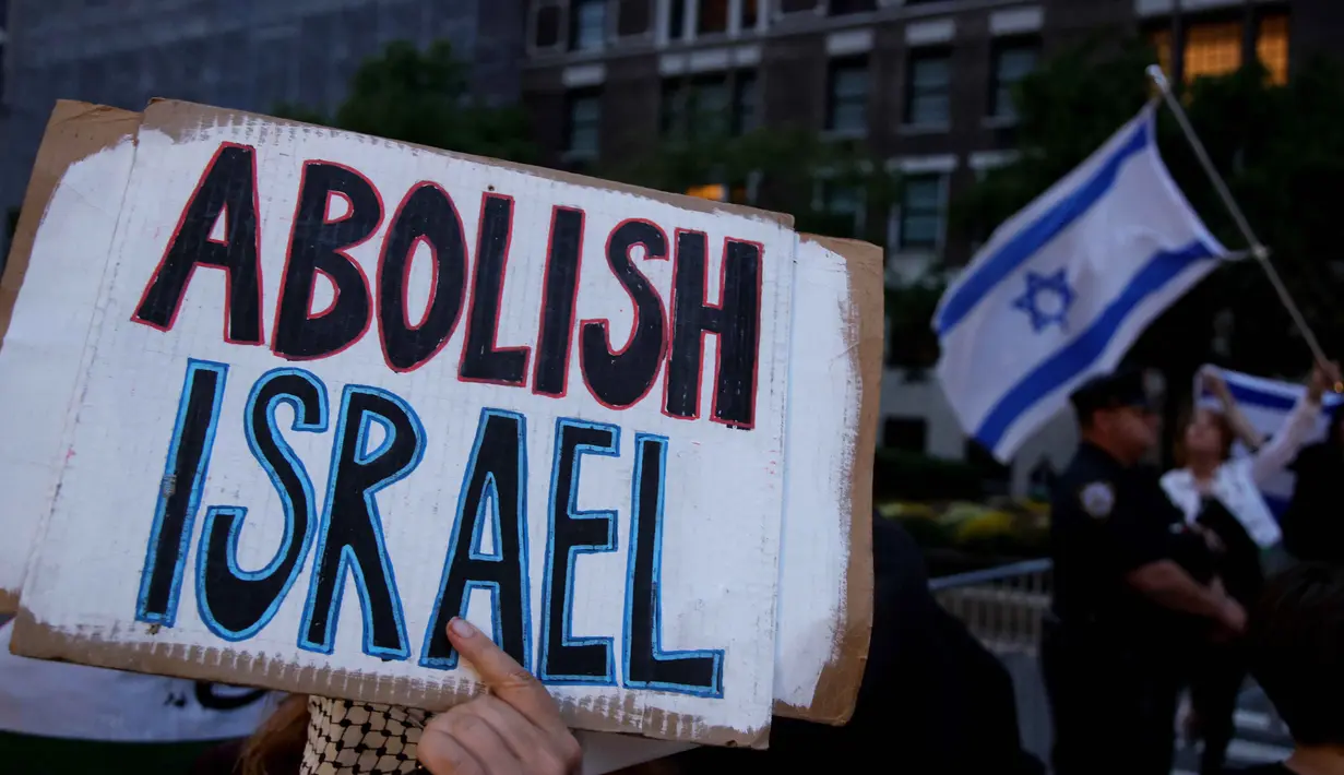 Seorang aktivis pro-Palestina memegang spanduk selama aksi unjuk rasa di luar hotel tempat Perdana Menteri Israel Benjamin Netanyahu berada di New York, Amerika Serikat pada 25 September 2025. (Leonardo MUNOZ/AFP)
