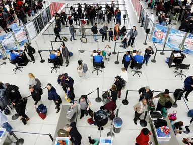 Wisatawan mengantre untuk melewati pos pemeriksaan keamanan di Bandara Internasional John F. Kennedy, New York, Rabu (21/11). Masyarakat Amerika mulai bergegas pulang ke kampung halamannya alias mudik untuk merayakan Thanksgiving Day. (AP/Mark Lennihan)