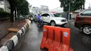 Pembatas jalan diletakkan menutup satu ruas Jalan Kemang Raya, Minggu (28/8). Penutupan terkait proses pengeringan lokasi parkir bawah tanah pertokoan akibat banjir yang terjadi sejak Sabtu malam (27/8). (Liputan6.com/Helmi Fithriansyah)
