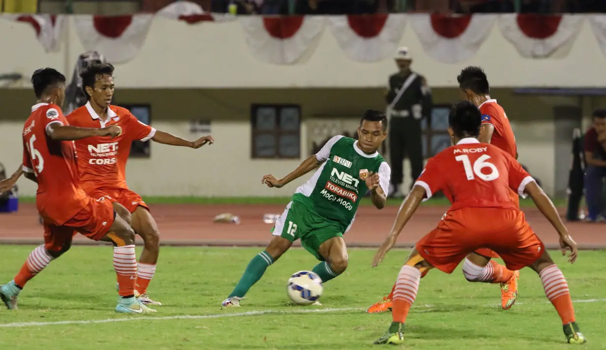 Pemain PS TNI, Erwin Ramdani (tengah), berusaha melewati hadangan pemain Persija pada lanjutan Grup D Piala Jenderal Sudirman 2015 di Stadion Manahan, Solo, Selasa (15/12/2015). Persija menang 1-0 atas PS TNI. (Bola.com/Nicklas Hanoatubun)