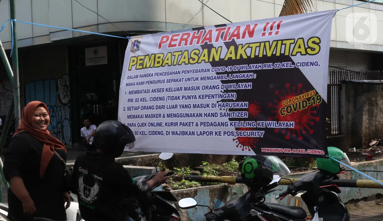 Spanduk tentang pembatasan aktivitas terpampang di pintu masuk perumahan di kawasan Cideng, Jakarta, Kamis (2/4/2020). Pemerintah menetapkan Pembatasan Sosial Berskala Besar dengan membatasi kegiatan tertentu penduduk di wilayah yang diduga terinfeksi COVID-19. (Liputan6.com/Helmi Fithriansyah)