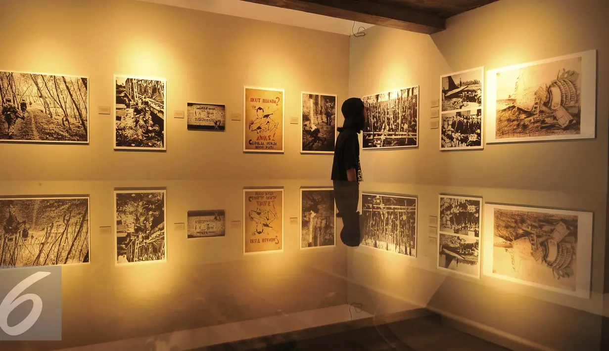 Seorang pengunjung mengamati foto yang dipamerkan dalam Pameran Foto & Peluncuran Buku 71th RI Bingkisan Revolusi di Galeri Foto Jurnalistik Antara, Jakarta, Senin (22/8). (Liputan6.com/Gempur M Surya)