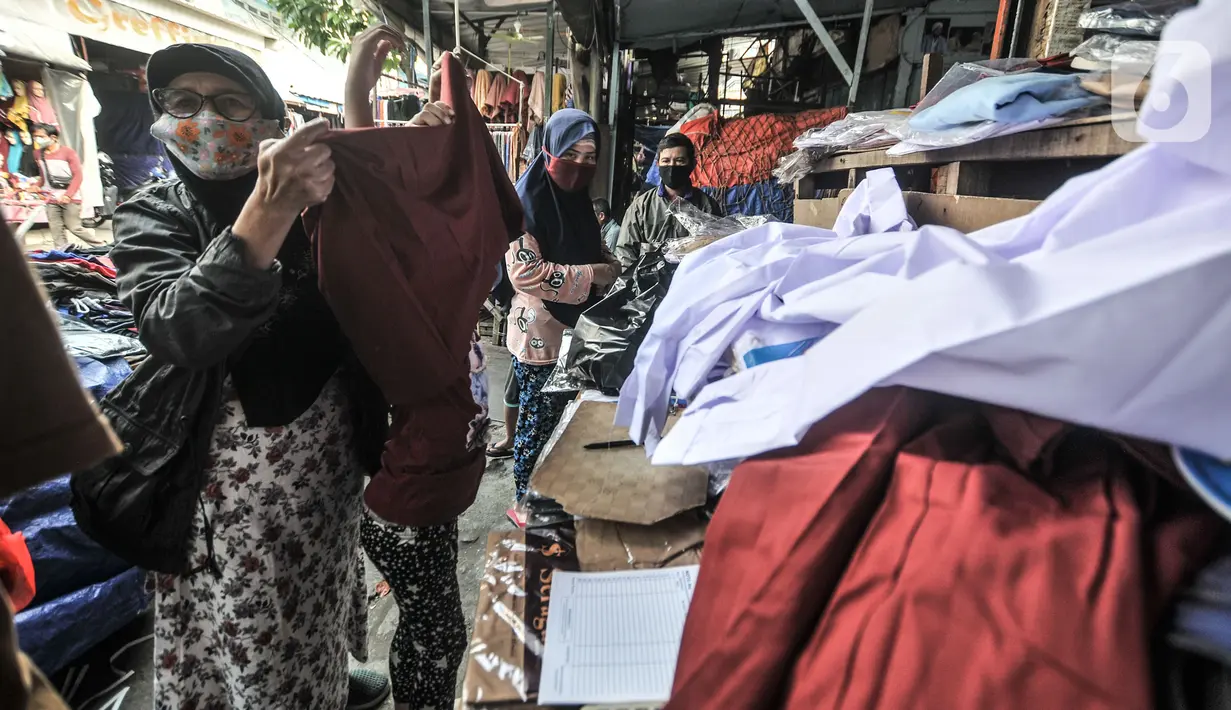 Warga memilih seragam sekolah di Jakarta, Rabu (14/7/2021). Meski telah memasuki Tahun Ajaran Baru, penjualan seragam mengalami anjlok akibat masih diberlakukannya pembelajaran secara daring seiring PPKM Darurat yang membatalkan rencana sekolah tatap muka pada Juli ini. (merdeka.com/Iqbal S Nugroho)