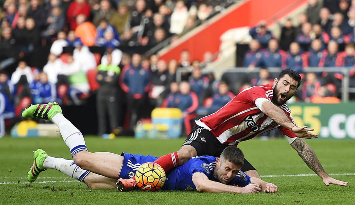 Bek Chelsea, Gary Cahill, terjatuh akibat berebut bola dengan striker Southampton, Charlie Austin. Pada laga ini wasit mengeluarkan empat kartu kuning. (Reuters/Dylan Martinez)