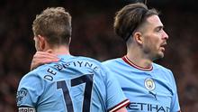 Pemain Manchester City, Kevin De Bruyne dan Jack Grealish melakukan selebrasi dalam pertandingan Liga Inggris 2022/2023 melawan Manchester United di Old Trafford, Sabtu (14/1/2023). Kemungkinan Kevin De Bruyne untuk membela Manchester City jika harus turun kasta sangatlah kecil. Apalagi De Bruyne masih ingin membawa Belgia berkibar di kancah Eropa dan dunia. (AFP/Oli Scarff)
