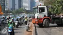 Petugas kepolisian mengatur lalu lintas akibat truk mengalami patah as di Jakarta, Selasa (29/9/2015). Imbas dari truk bermuatan alat berat mengalami patah as itu, Jalan Sudirman mengarah ke Jalan MH Thamrin terpantau padat. (Liputan6.com/Gempur M Surya)