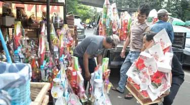 Pedagang menaikan parcel ke atas mobil di kawasan Pasar kembang, Cikini, Jakarta, Jumat (16/12). Jelang hari raya Natal, pedagang parcel di kawasan Cikini masih sepi pembeli. (Liputan6.com/Yoppy Renato)