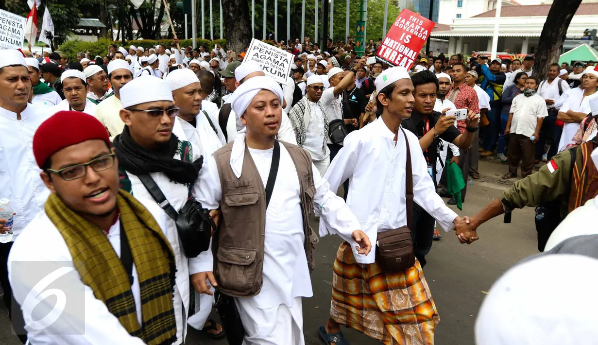Penyanyi religi, Opick berjalan kaki bersama massa aksi damai 4 November melewati Balai Kota Jakarta menuju ke Istana Merdeka, Jumat (4/11). Aksi ini menuntut penuntasan proses hukum terhadap Basuki Tjahaja Purnama (Ahok). (Liputan6.com/Faizal Fanani)