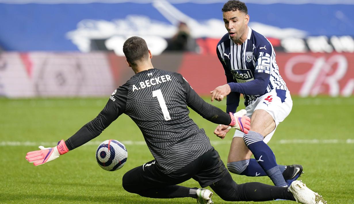 Kiper Liverpool, Alisson Becker, berusaha menghalau bola tendangan pemain West Bromwich Albion, Hal Robson-Kanu, pada laga Liga Inggris di Stadion the Hawthorns, Minggu (16/5/2021). Liverpool menang dengan skor 2-1. (Tim Keeton/Pool via AP)